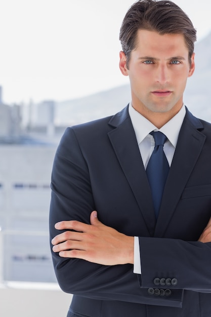 Handsome businessman standing with arms crossed 