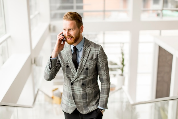 Handsome businessman talking on mobile phone while standing on the stairs