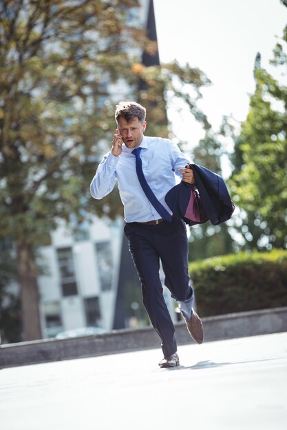 Photo handsome businessman talking on mobile phone