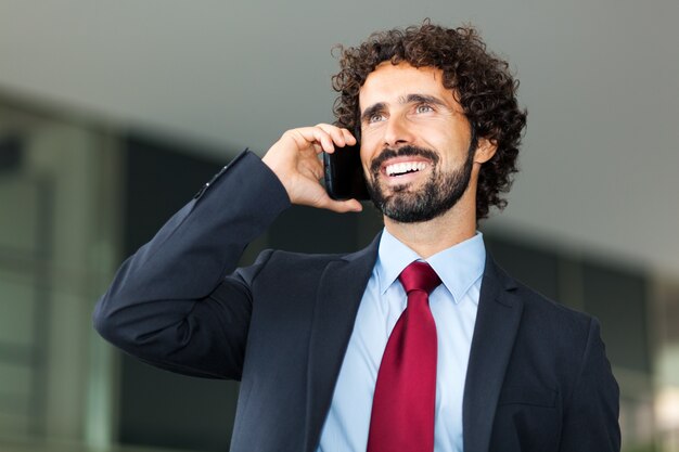 Foto uomo d'affari bello che parla sul telefono cellulare