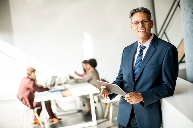 Handsome businessman using his digital tablet in the office