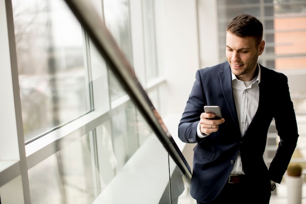 Handsome businessman using smartphone in the office