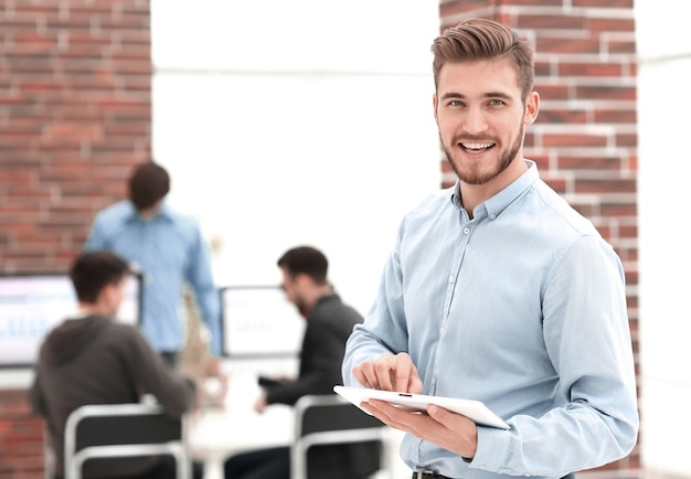 Handsome businessman using a tablet in the office