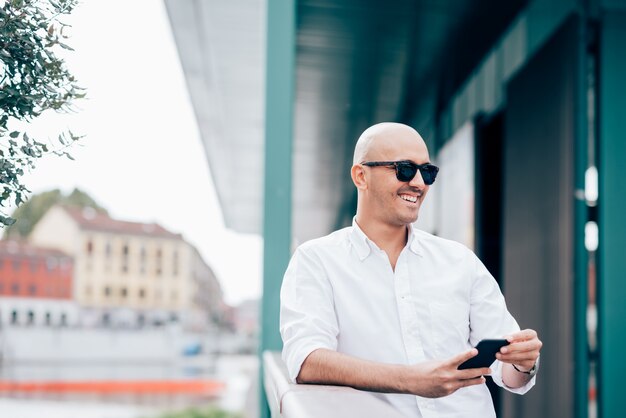 Photo handsome businessman wearing sunglasses, leaning on a handrail