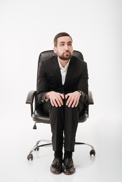 Photo handsome businessman over white wall sitting on chair.