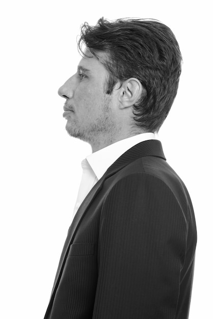 Photo handsome businessman with beard stubble in suit isolated against white wall in black and white