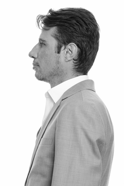 Photo handsome businessman with beard stubble in suit isolated against white wall in black and white