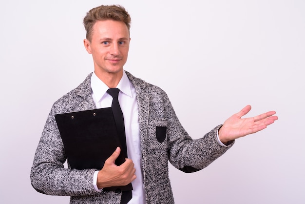  handsome businessman with blond curly hair against white wall