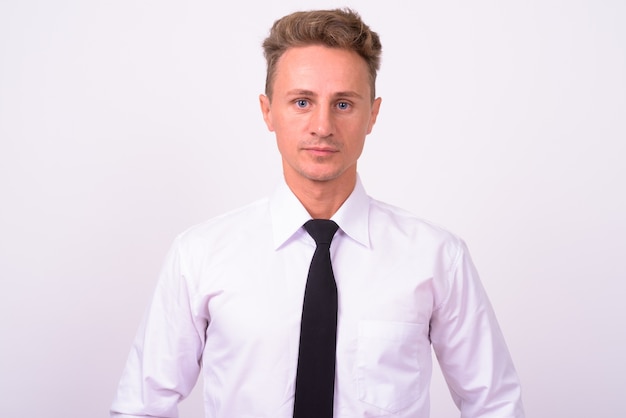  handsome businessman with blond curly hair against white wall