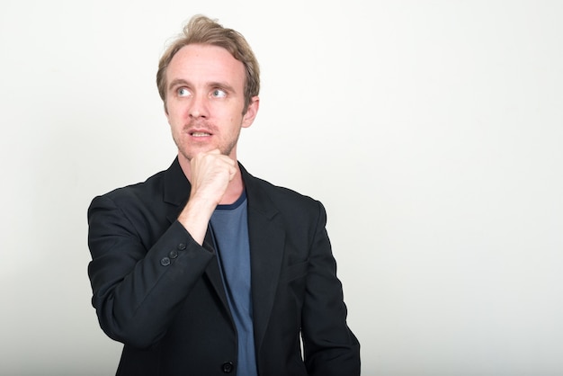  handsome businessman with blond hair against white wall