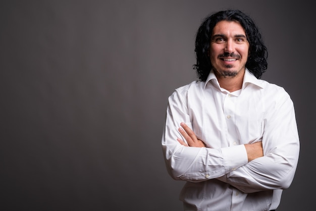 Handsome businessman with mustache against gray wall