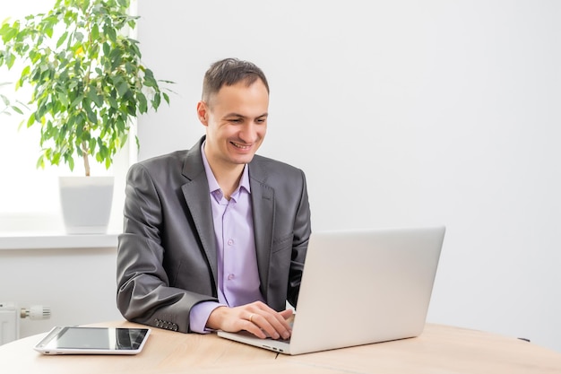 Handsome businessman working with laptop in office.