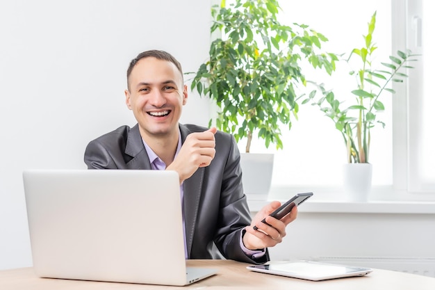 Handsome businessman working with laptop in office.