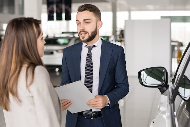 Handsome Car Salesman Consulting Woman