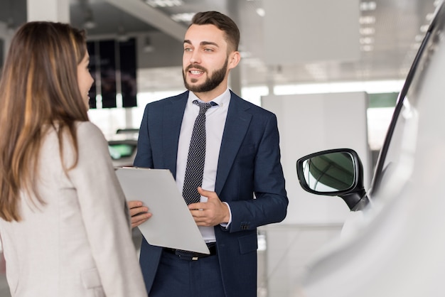 Venditore di automobili bello che vende automobili