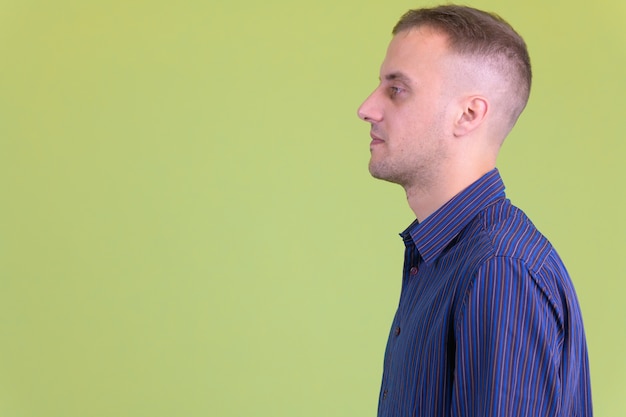 Photo handsome casual businessman against colored wall