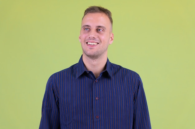  handsome casual businessman against colored wall