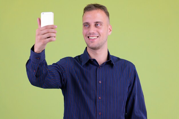  handsome casual businessman against colored wall