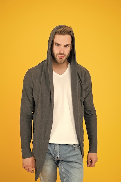 Handsome and casual Handsome man yellow background Young guy wear hooded sweatshirt Handsome model with fashion look Fashion and style Handsome and confident