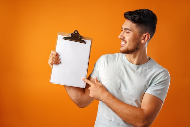 Handsome casual man in white shirt showing clipboard