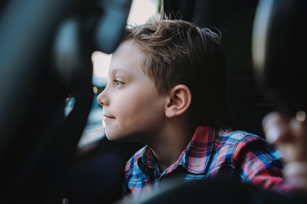 Handsome caucasian boy travelling by car sitting in child seatRecreation concept