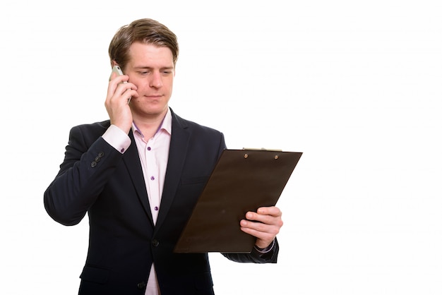 Handsome Caucasian businessman reading clipboard while talking o