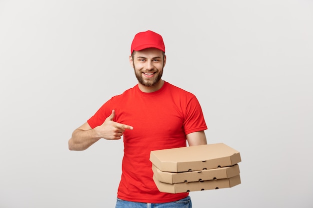 Handsome caucasian Pizza delivery man pointing finger. Isolated over grey background.