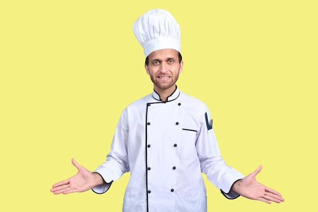 handsome chef cook white outfit over yellow background indian pakistani model