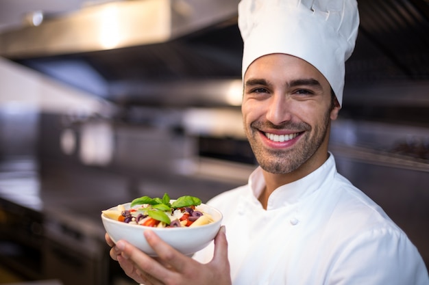 Foto cuoco unico bello che presenta pasta