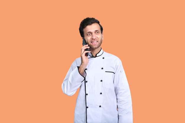 красивый шеф-повар разговаривает по телефону в белом наряде индийская пакистанская модель