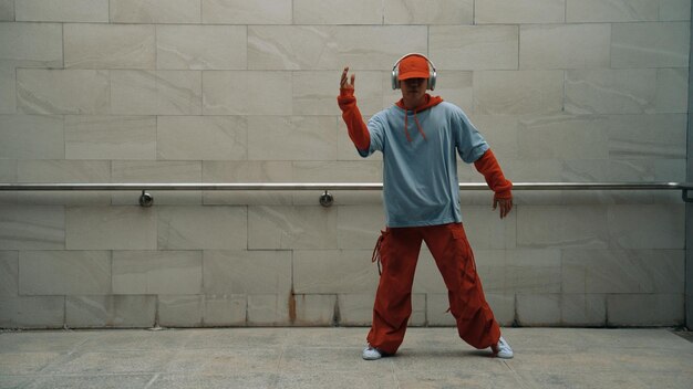 Handsome choreographer practice street dance in gray background Sprightly