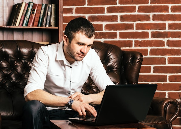 Handsome and confident business man freelancer with device in official suit