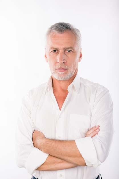 Handsome confident businessman with gray beard crossing hands