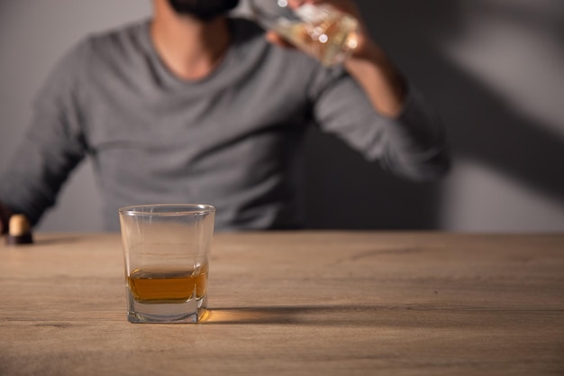 Handsome depressed man drinking whiskey