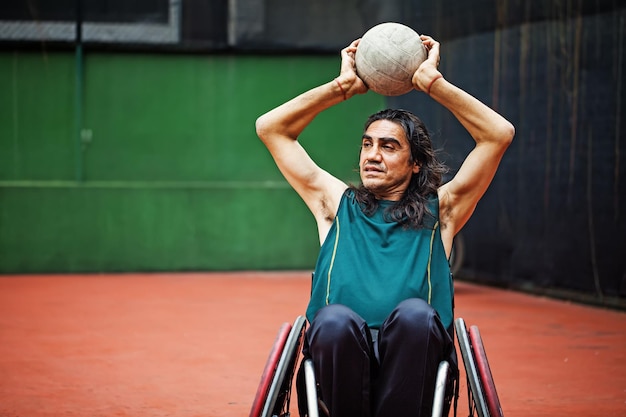 Handsome determined disabled rugby player in a wheelchair practicing on a stadium