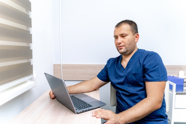 インターネットを介して患者との医療相談をしているハンサムな医者。コンピュータ遠隔医療診断。 Covidの制限。