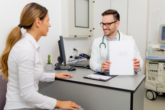 Handsome doctor is talking with young female patient