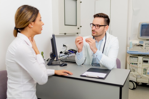 Handsome doctor is talking with young female patient