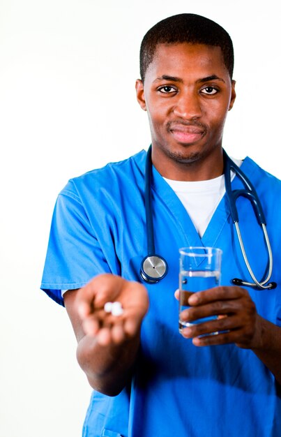 Handsome doctor in scrubs with pills and glass of water