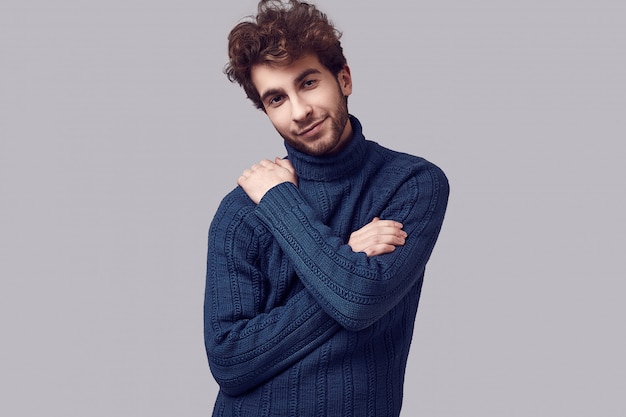 Handsome elegant man with curly hair in blue sweater