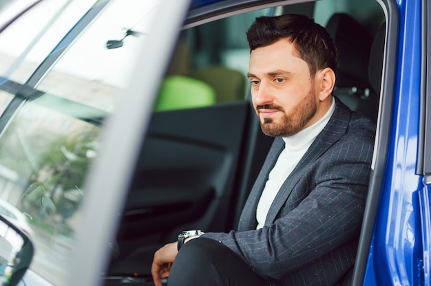 Handsome elegant serious man drives a car