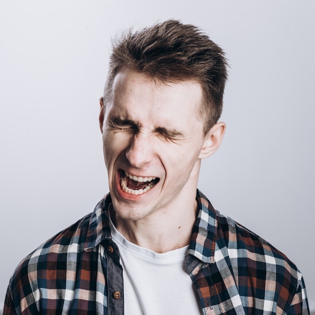 Handsome emotional man isolated over gray background