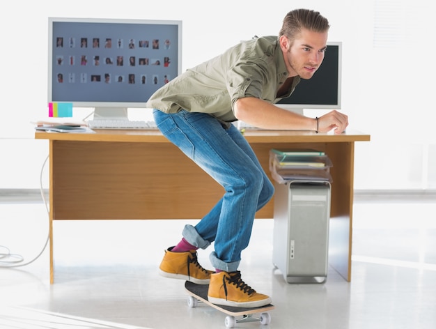 Photo handsome employee skating through the office