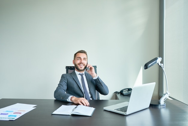 Handsome Entrepreneur Speaking by Phone in office