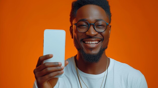 Handsome Excited Man Posing Over Orange Studio Background Pointing At White Empty Smartphone Screen Smiling At Camera Check It Out Cellphone Display MockUp