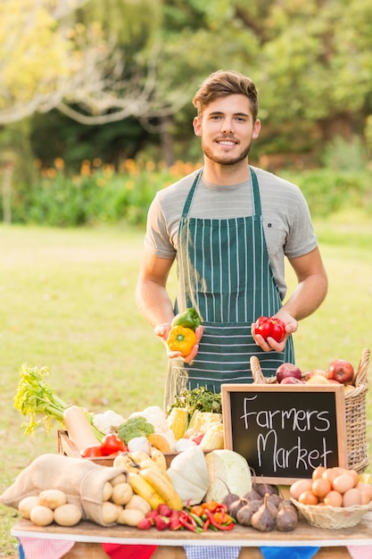 Handsome farmer holding peppers 