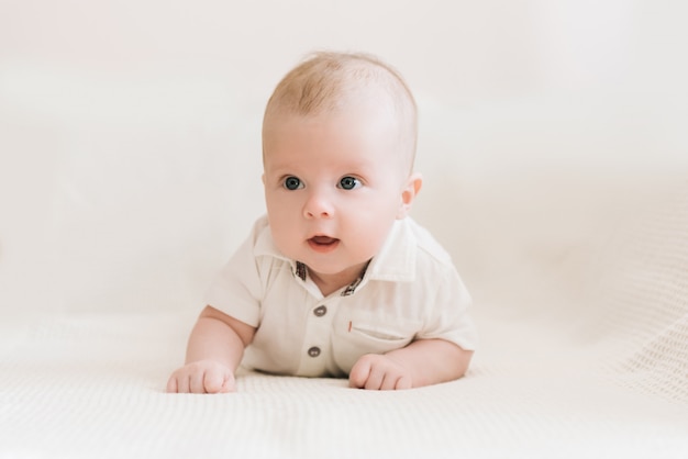 Handsome fashionable little boy lying on a blanket, with a sweet expression