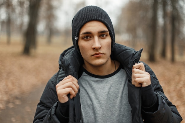 Foto uomo alla moda bello in un cappello lavorato a maglia nero con una giacca invernale