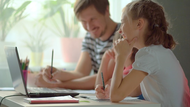 Photo handsome father helping his children with homework