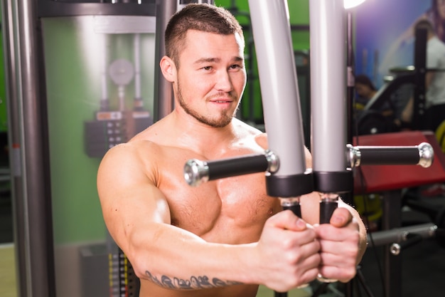 Handsome fitness man works out in gym